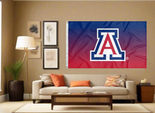 Load image into Gallery viewer, gradient style 3x5 University of Arizona Flag with two metal grommets for indoor home decor covering tan wall of living room
