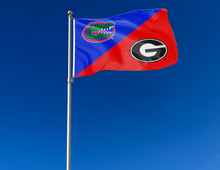 Load image into Gallery viewer, blue and red house divided florida georgia game flag attached to flagpole waving in the wind
