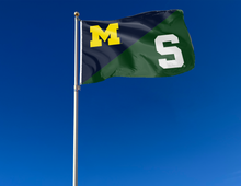 Load image into Gallery viewer, blue and green Michigan MSU House divided with S Logo attached to flagpole waving in the wind
