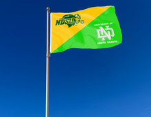 Load image into Gallery viewer, gold and green NDSU North Dakota House Divided Flag attached to flagpole waving in the wind
