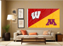 Load image into Gallery viewer, red and gold Wisconsin Minnesota House Divided Flag with two metal grommets covering tan wall of living room
