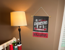 Load image into Gallery viewer, Black and Red 2 Panel 13x18 inch long University of Georgia SEC Football Championship 2024 Champions Garden Flag hanging on banner pole covering a well-lit brown living room wall
