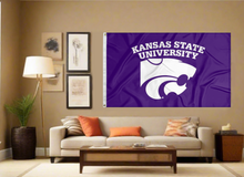 Load image into Gallery viewer, Purple 3x5 foot wide Kansas State University Flag with two metal grommets covering the tan wall of a well-lit room
