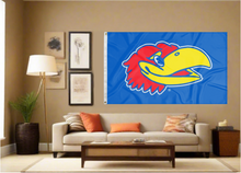 Load image into Gallery viewer, University of Kansas flag with jayhawk head logo hung inside as part of man cave decor
