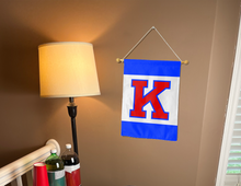 Load image into Gallery viewer, university of kansas garden flag with three panel K logo hung on banner pole next to a lamp and drinks
