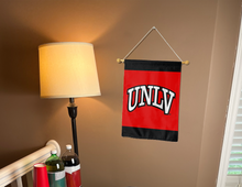 Load image into Gallery viewer, UNLV garden flag hung on a banner pole inside a college dorm for decor
