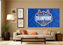 Load image into Gallery viewer, blue Florida Basketball March Madness 2025 Champions 3x5 Flag for indoor home décor covering tan wall of well lit room
