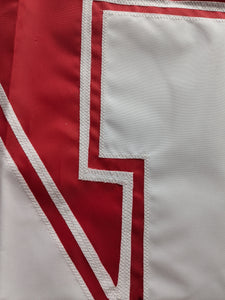 Close up shot of white hand-sewn nebraska huskers logo on red university of nebraska applique flag