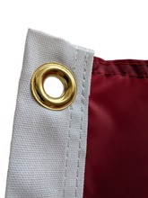 Load image into Gallery viewer, Close-up of a gold grommet on a red University of Alabama Applique Flag
