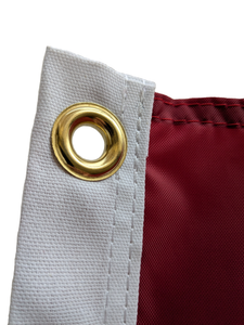 Close-up of a gold grommet on a red University of Alabama Applique Flag
