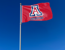 Load image into Gallery viewer, Red quadruple stitched flyends of 3x5 foot wide University of Arizona Flag with two metal grommets attached to flagpole waving in the wind for outdoor home decor
