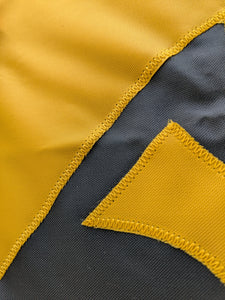 Close-up of a section of a yellow and black University of Iowa National Applique flag, showing the detailed stitching and fabric texture.