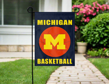 Load image into Gallery viewer, blue michigan basketball logo garden flag hung on a garden flag stand outside
