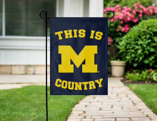Blue University of Michigan Garden flag with this is Michigan Country logo hung on garden flag stand