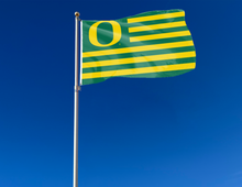 Load image into Gallery viewer, University Of Oregon National 3x5 Flag with seven green stripes and six gold stripes attached to flagpole waving in the wind
