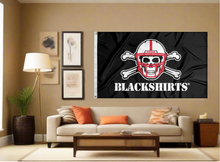 Load image into Gallery viewer, Black 3x5 University of Nebraska Flag with New Nebraska Blackshirts Logo and two metal grommets covering the tan wall of a well-lit room
