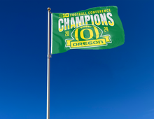Load image into Gallery viewer, 3x5 foot Green University of Oregon Football BIG Ten Football Championship 2024 Champions Flag with two metal grommets attached to a flagpole waving in the wind
