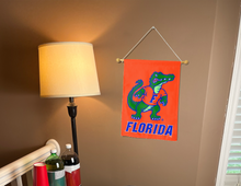 Load image into Gallery viewer, florida garden flag with albert gator logo hung inside a well lit college dorm
