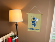 Load image into Gallery viewer, gold georgia tech garden flag hung inside a well lit college dorm 
