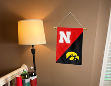 Load image into Gallery viewer, house divided garden flag with nebraska iowa rivalry logo hung inside for college dorm decor
