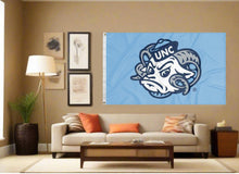 Load image into Gallery viewer, indoor display of blue unc rameses mascot flag for man cave decor
