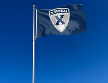 Load image into Gallery viewer, outdoor display of blue xavier university flag with shield logo for tailgate decor
