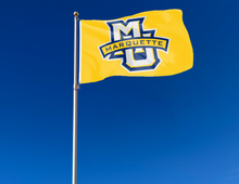 Load image into Gallery viewer, outdoor display of gold marquette university flag with mu marquette logo for tailgate decor
