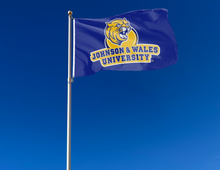 Load image into Gallery viewer, outdoor display of blue johnson wales university wildcats flag for tailgate decor
