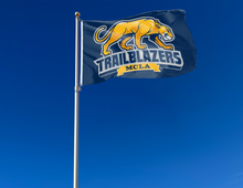 Load image into Gallery viewer, outdoor display of Massachusetts College of Liberal Arts trailblazers flag for tailgate decor
