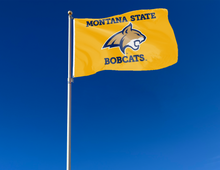 Load image into Gallery viewer, outdoor display of gold montana state university bobcats flag for tailgate decor
