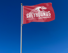 Load image into Gallery viewer, outdoor display of red university of indianapolis greyhounds flag for tailgate decor
