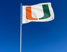 Load image into Gallery viewer, outdoor display of white university of miami flag as part of tailgate decor
